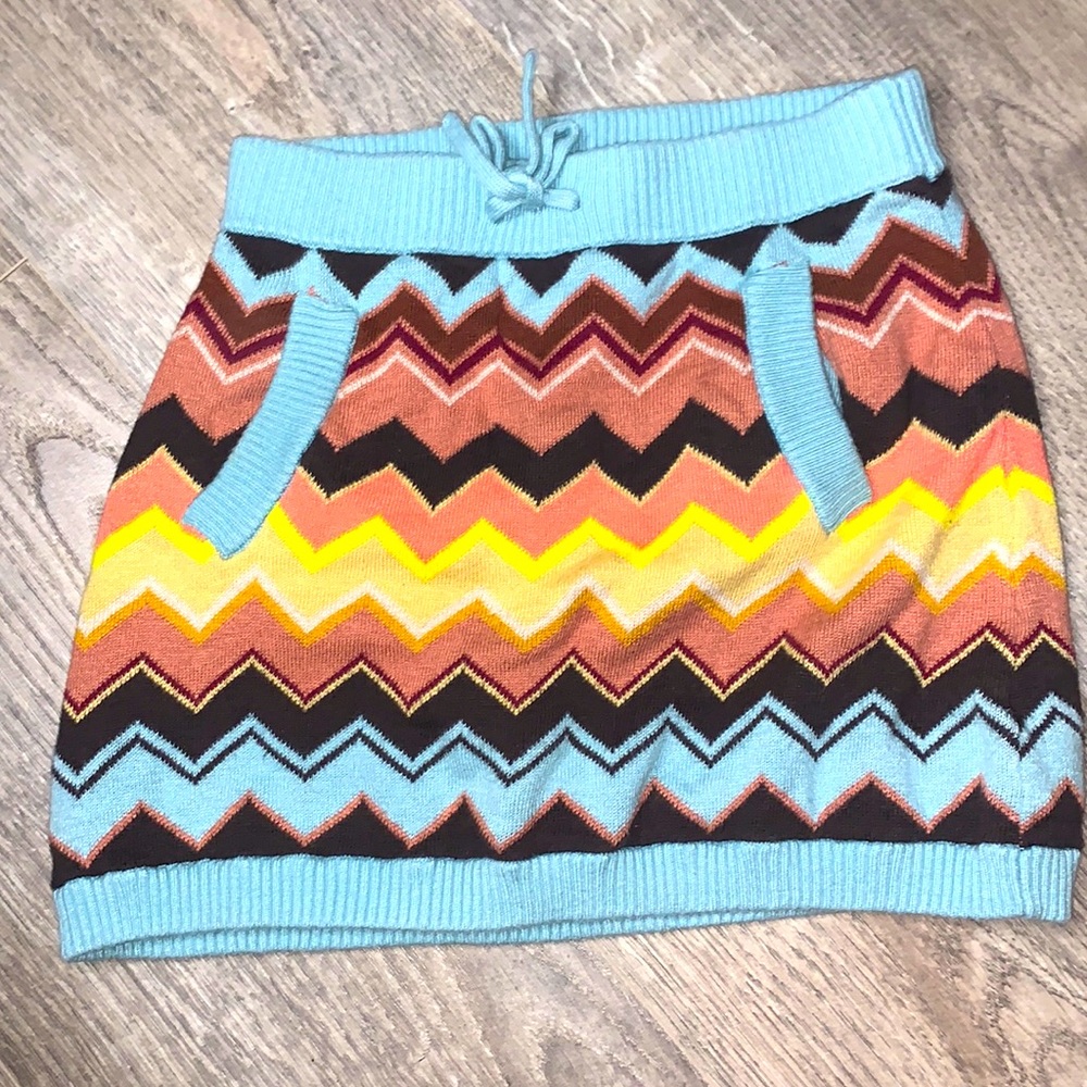 It has pockets and has a tie in the middle. It is also muti colored.